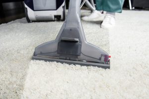 Carpet cleaning in the living room using a vacuum