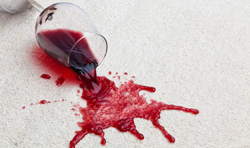 Fresh red wine spilled on a light-coloured carpet