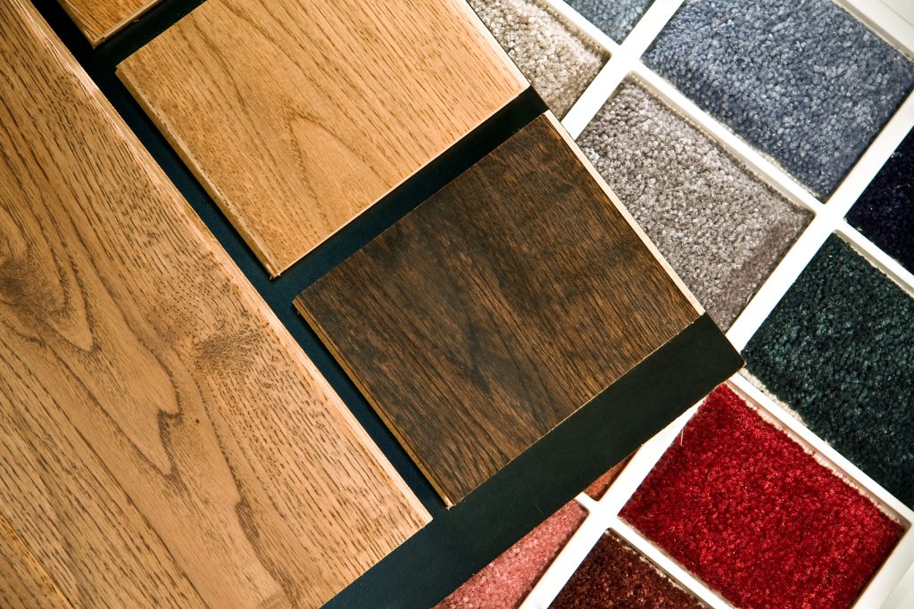 Choosing between carpet vs vinyl flooring samples in a showroom